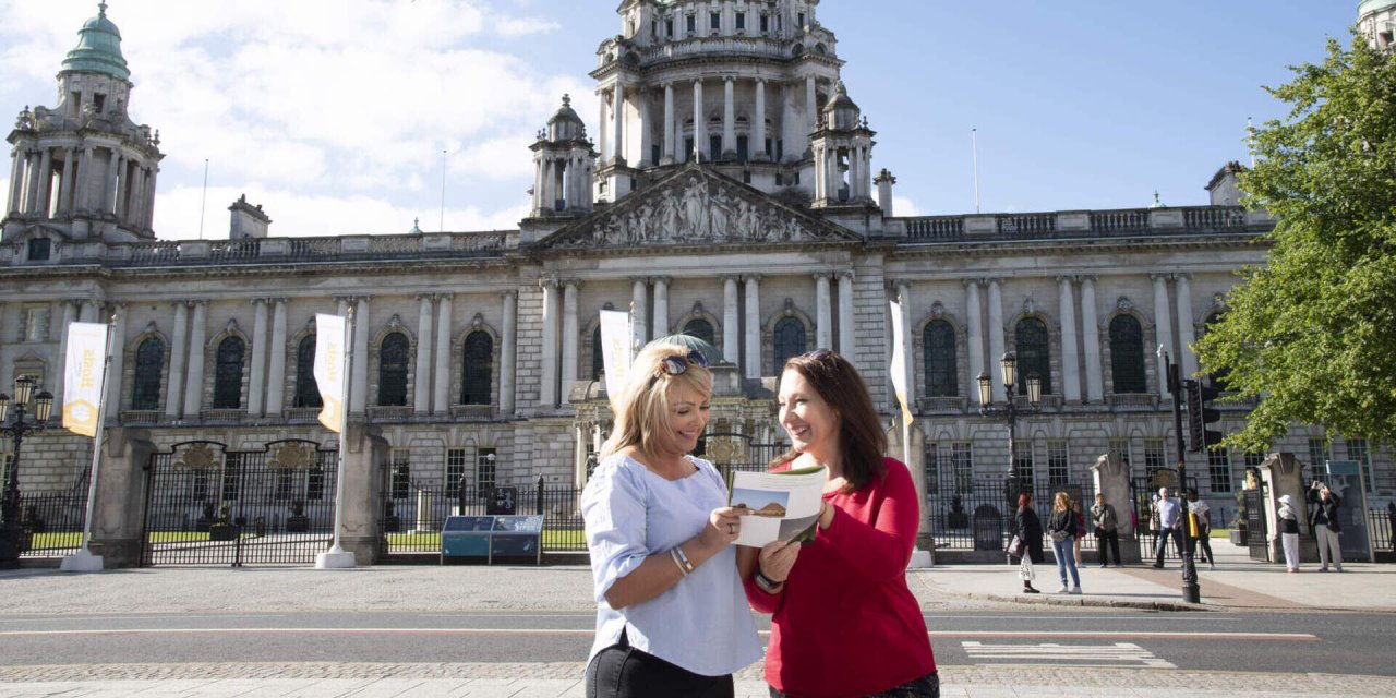 two women in front of large stone building 