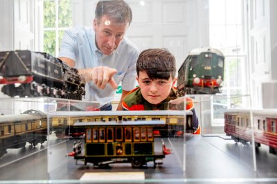 Boy and Adult enjoying train exhibition at casino model railway